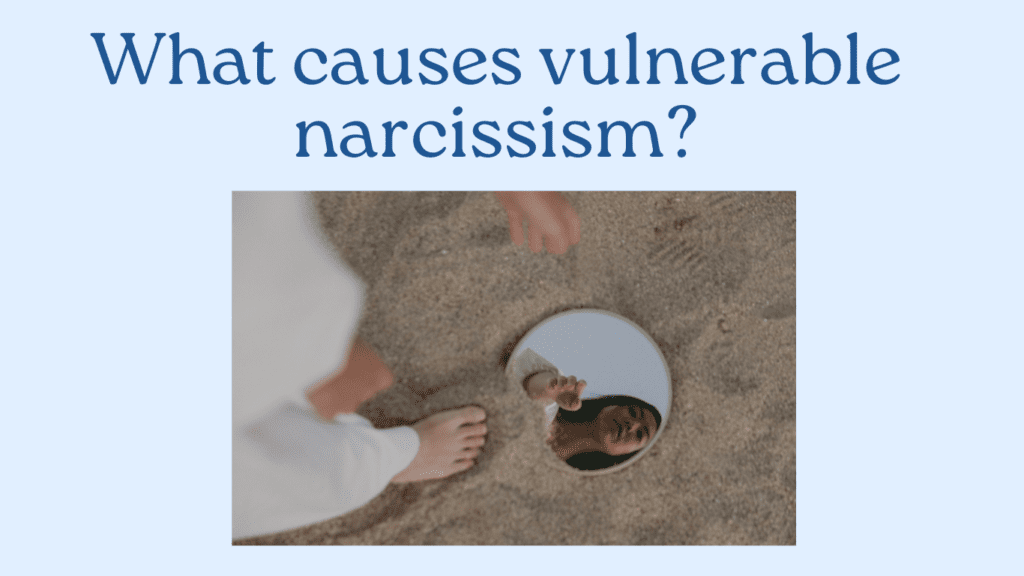 A person gazes into a mirror resting on the sand, their face reflecting back at them. The scene poses a thought-provoking question: What causes vulnerable narcissism?